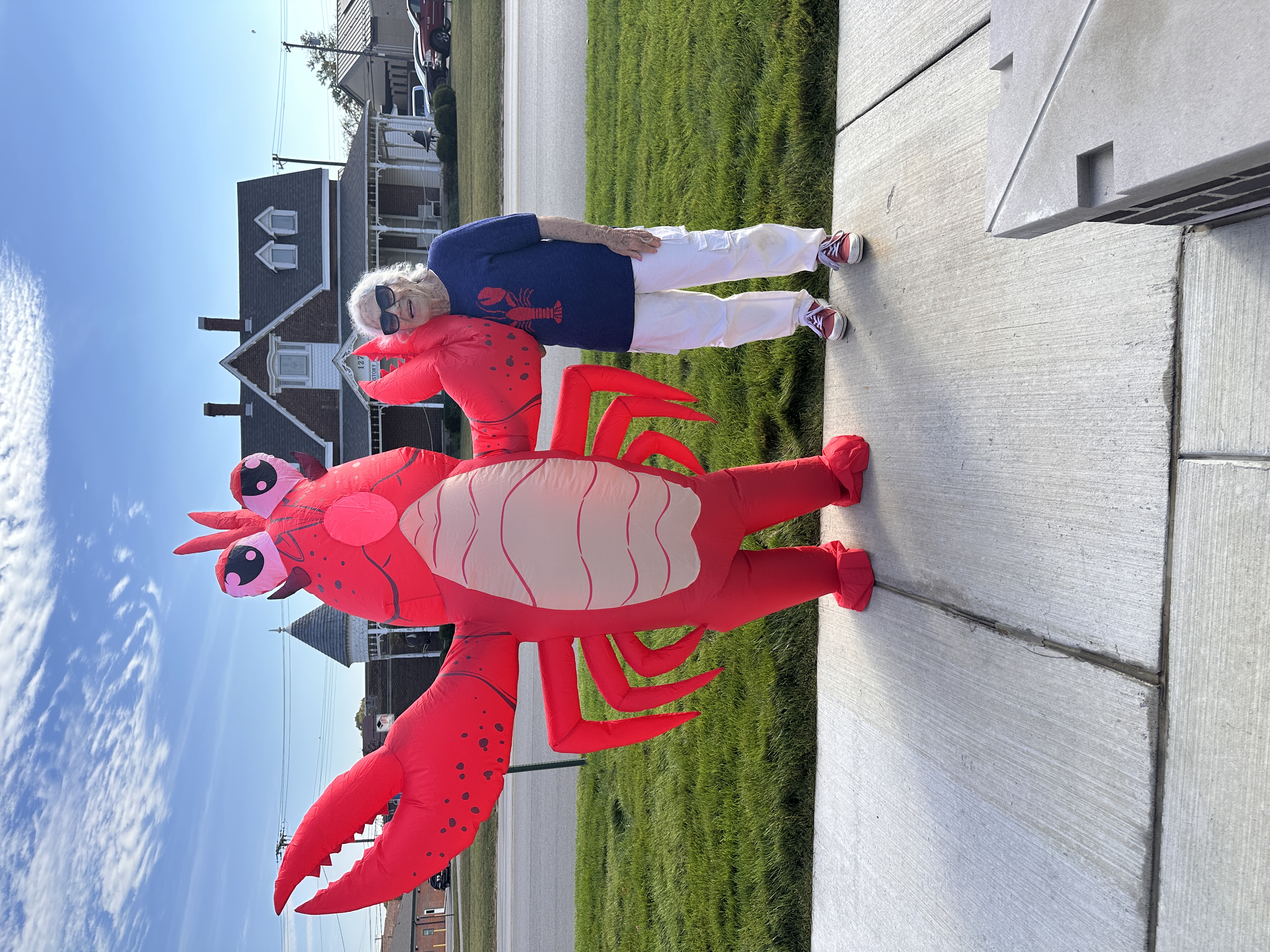 Costumed protestor wearing an inflatable lobster standing next to a woman wearing a blue sweater with a red lobster on the front.