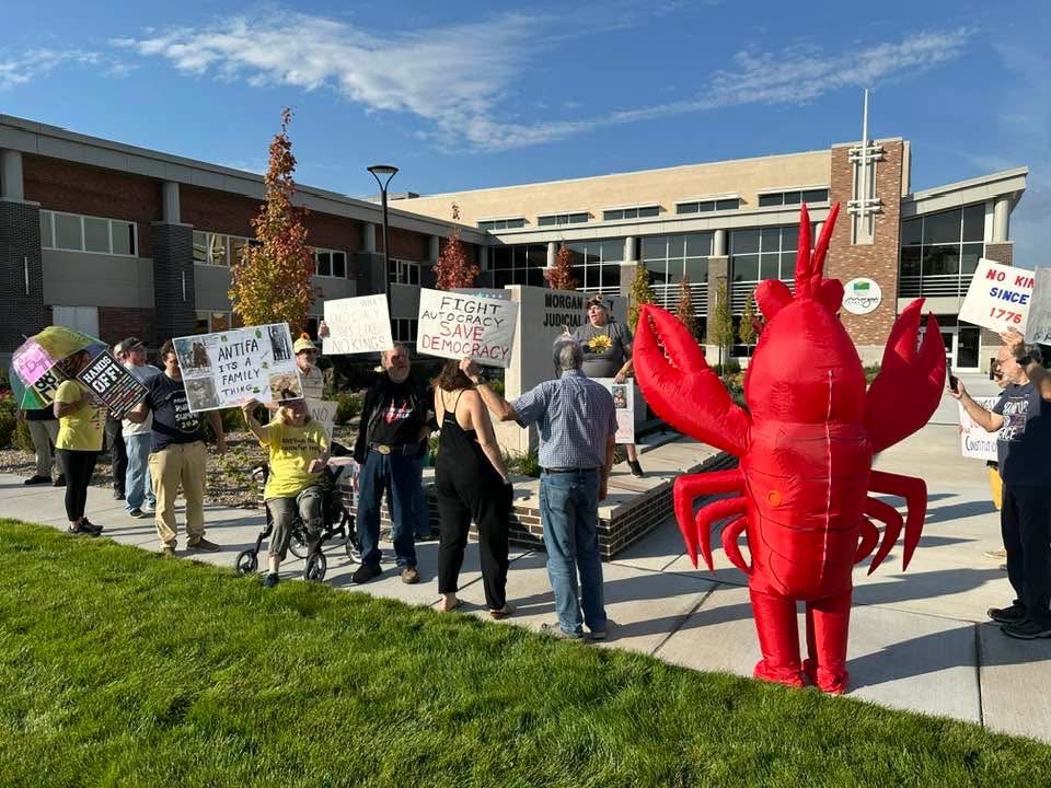 Image of protestors outside the Admin Building in Martinsville, listening to Michelle Higgs read the Letter to King George III from the Declaration of Independence.